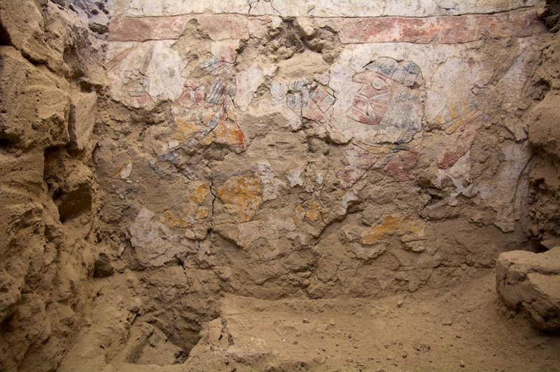 Mural en el que se representan dos mujeres sentadas mostrando hilos de colores y herramientas de hilar o tejer.