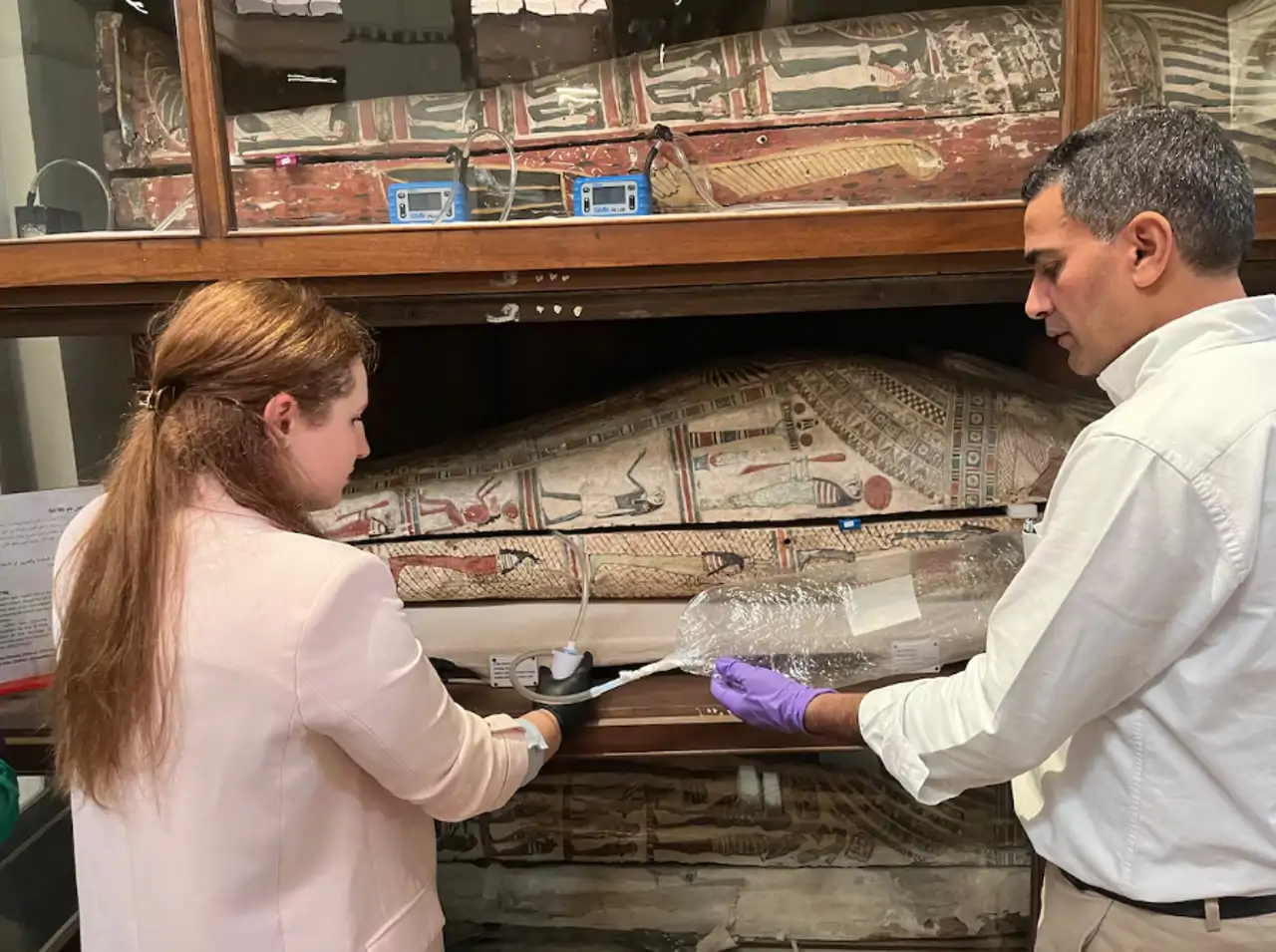 Emma Paolin y Abdelrazek Elnaggar toman muestras del interior de un sarcófago para el estudio.