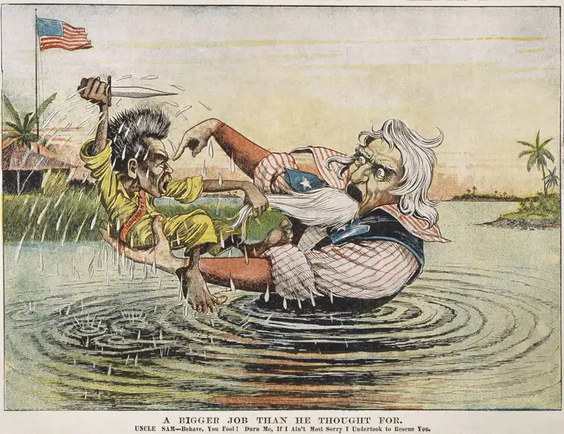El Tío Sam se hunde en el lodazal de la insurgencia filipina, personificada por Emilio Aguinaldo, que se resiste a ser rescatado. Caricatura publicada en un periódico estadounidense en abril de 1899.