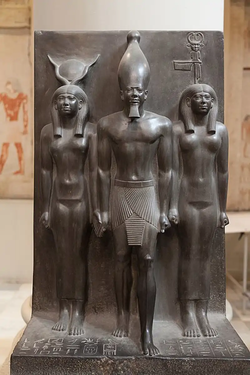 Tr&#237;ada del fara&#243;n Micerino, acompa&#241;ado por la diosa Hathor y la personificaci&#243;n del nomo de Di&#243;spolis Parva. Museo Egipcio, El Cairo. &amp;nbsp;
